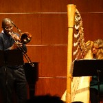 Kenneth Thompkins performing on trombone with harp accompanist.